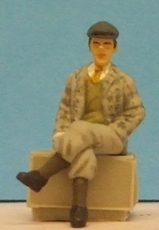 Omen - Man seated with crossed legs wearing a cap & plus-fours